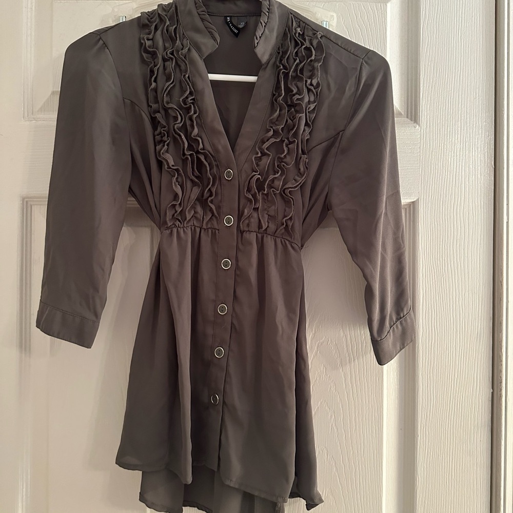 Button up in front and has a tie in the back. Sheer like material
